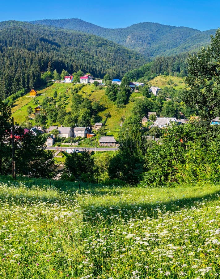 Casas rurais bonitas situadas em uma área pitoresca entre inclinações e árvores verdes perto da estrada fotografia de stock royalty free Casas rurais bonitas situadas em uma área pitoresca entre inclinações e árvores verdes perto da estrada fotografia de stock royalty free