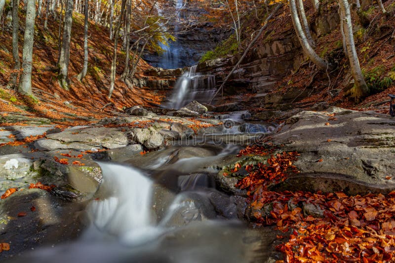 Cascade avec courant de montagne parmi le feuillage d'automne. image libre de droits