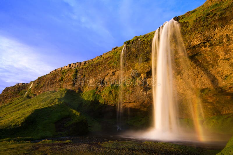 Cascade à écriture ligne par ligne de Seljalandfoss au coucher du soleil, Islande photographie stock Cascade à écriture ligne par ligne de Seljalandfoss au coucher du soleil, Islande photographie stock