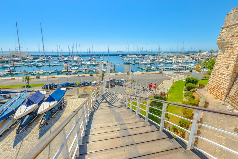 Cascais, Portugal - August 6, 2017: boats anchored at Marina de Cascais alongside Fortress of Our Lady of Light. Cascais is Portuguese fishing town and most popular holiday destination on Lisbon coast. Cascais, Portugal - August 6, 2017: boats anchored at Marina de Cascais alongside Fortress of Our Lady of Light. Cascais is Portuguese fishing town and most popular holiday destination on Lisbon coast