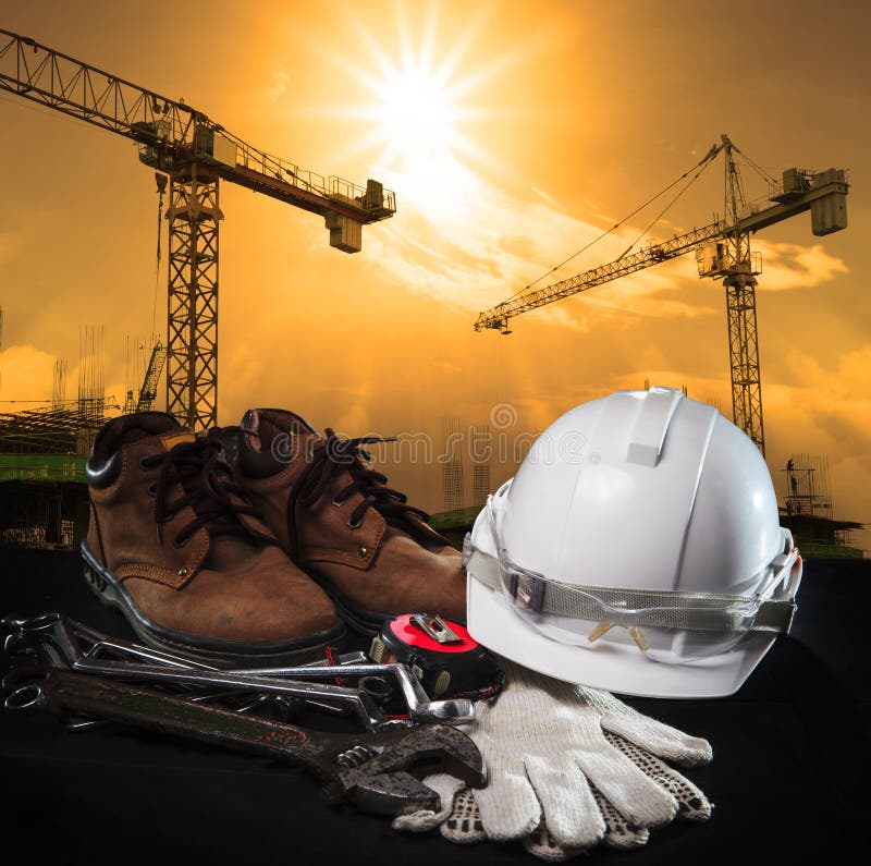 Casco e attrezzatura per l'edilizia con i agains della gru e della costruzione immagine stock Casco e attrezzatura per l'edilizia con i agains della gru e della costruzione immagine stock