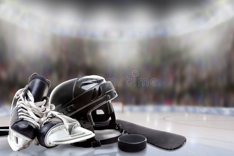 Casco, pattini, bastone e disco del hockey su ghiaccio in pista di pattinaggio
