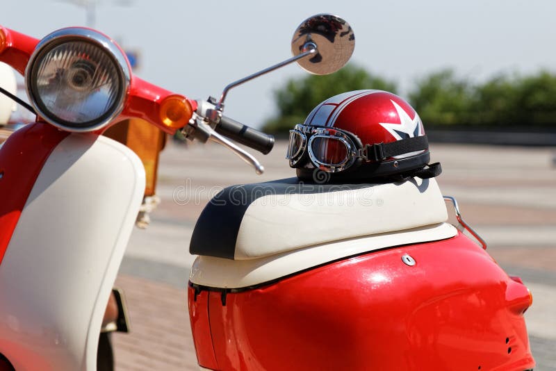 Casco y vidrios de Moto en el asiento de la vespa de motor fotos de archivo libres de regalías Casco y vidrios de Moto en el asiento de la vespa de motor fotos de archivo libres de regalías