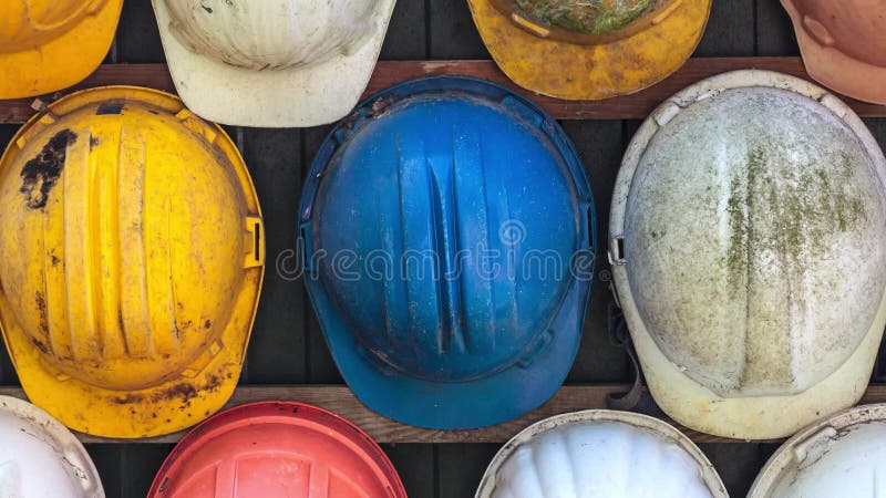 Cascos de construcción antiguos y desgastados y coloridos