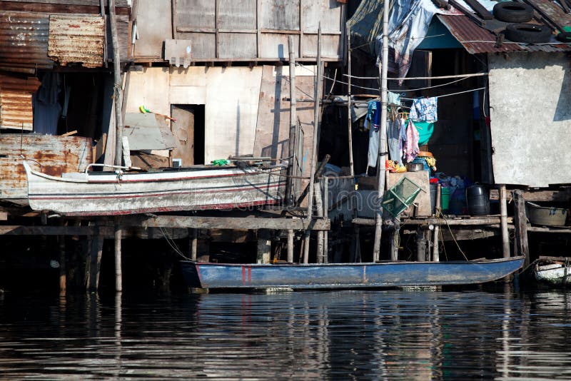 Case dell'occupatore abusivo della baracca lungo il fiume filippino immagini stock libere da diritti Case dell'occupatore abusivo della baracca lungo il fiume filippino immagini stock libere da diritti