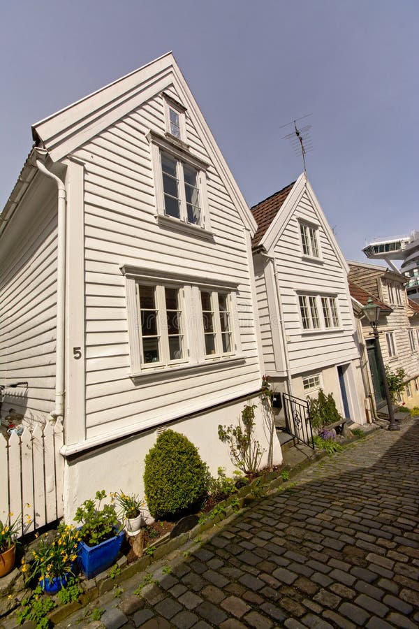 Case di legno bianche tradizionali lungo una via del ciottolo nella vecchia città di Stavanger, Norvegia immagini stock Case di legno bianche tradizionali lungo una via del ciottolo nella vecchia città di Stavanger, Norvegia immagini stock