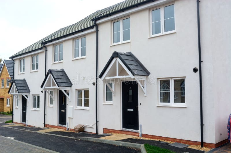 A line of 3 new build, white painted terrace houses on a housing estate. A line of 3 new build, white painted terrace houses on a housing estate.