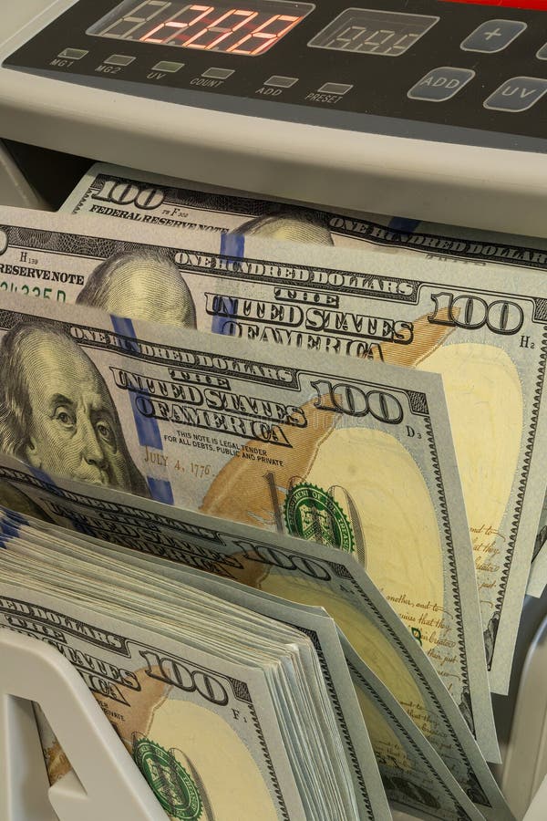 Cash counting machine displaying one hundred dollar bills in use royalty free stock photography