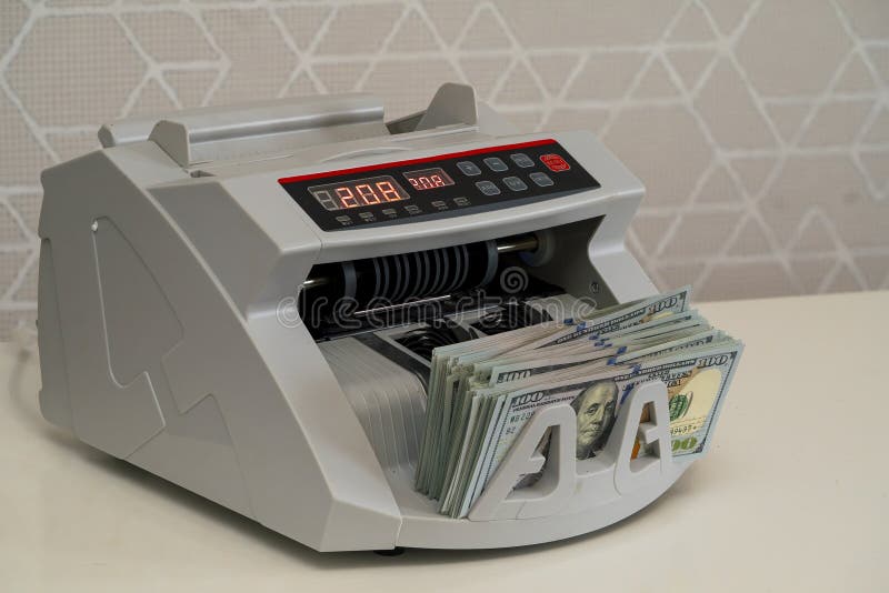 Cash counting machine efficiently processing dollar bills at a bank stock images