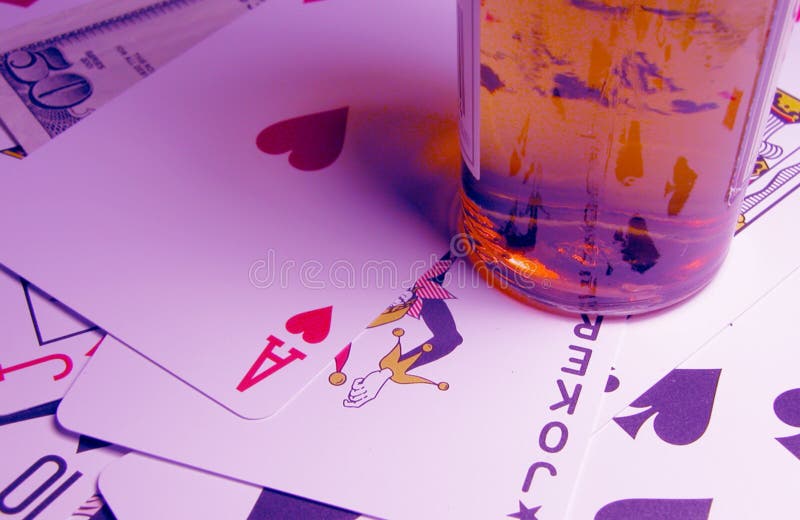 Alcohol,cards,some money and a specific light to create a casino ambient in this image.