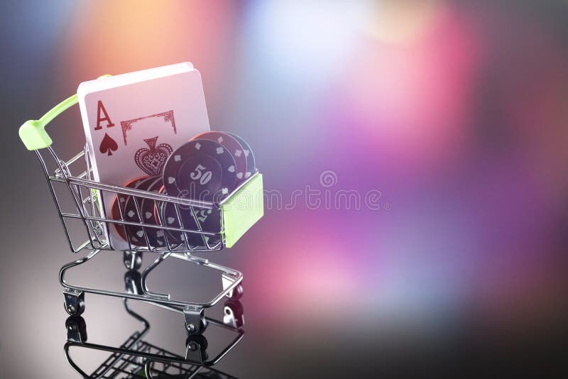 Casino chips and cards for playing the casino in a cart on a background with bokeh. Online gambling. Dependence