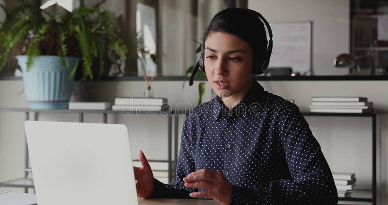 Casque de port de femme d'affaires indienne sûre faisant de l'appel conférence vidéo