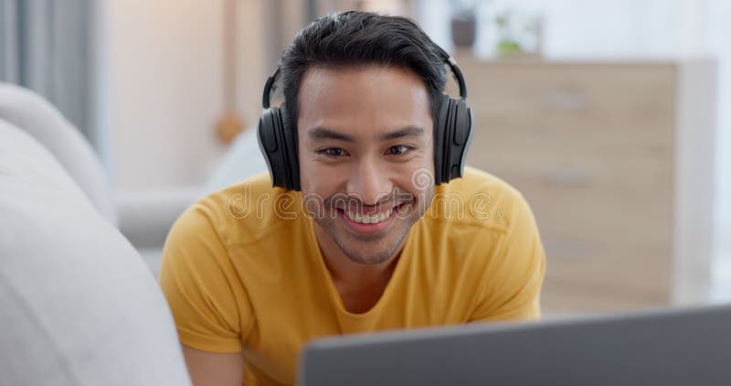 Casque ordinateur portable et jeune homme sur un canapé regardant une comique ou un film comique drôle dans le salon. rire heureux banque de vidéos