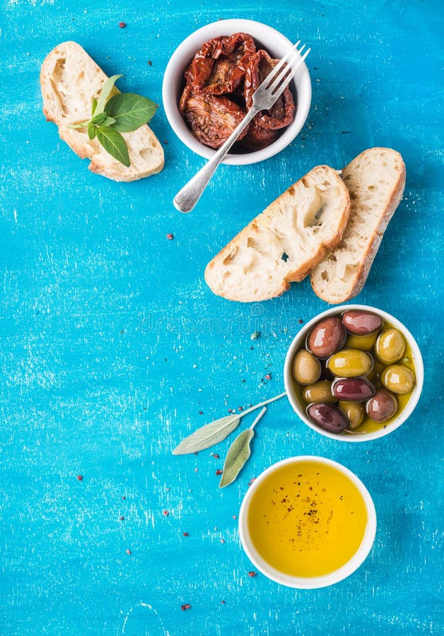 Casse-croûte méditerranéens réglés Olives, pétrole, tomates séchées au soleil, herbes et pain coupé en tranches de ciabatta dessu photos libres de droits Casse-croûte méditerranéens réglés Olives, pétrole, tomates séchées au soleil, herbes et pain coupé en tranches de ciabatta dessu photos libres de droits