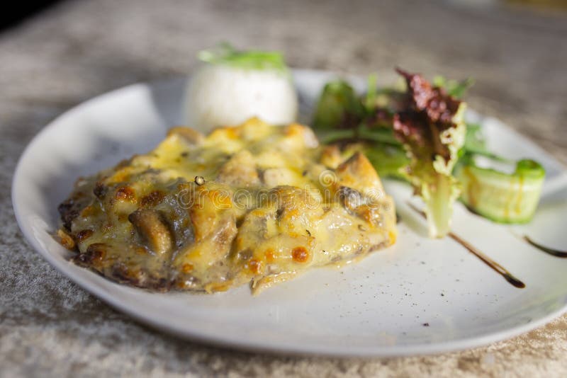 mushroom casserole with rice and herbs on a white plate. mushroom casserole with rice and herbs on a white plate.