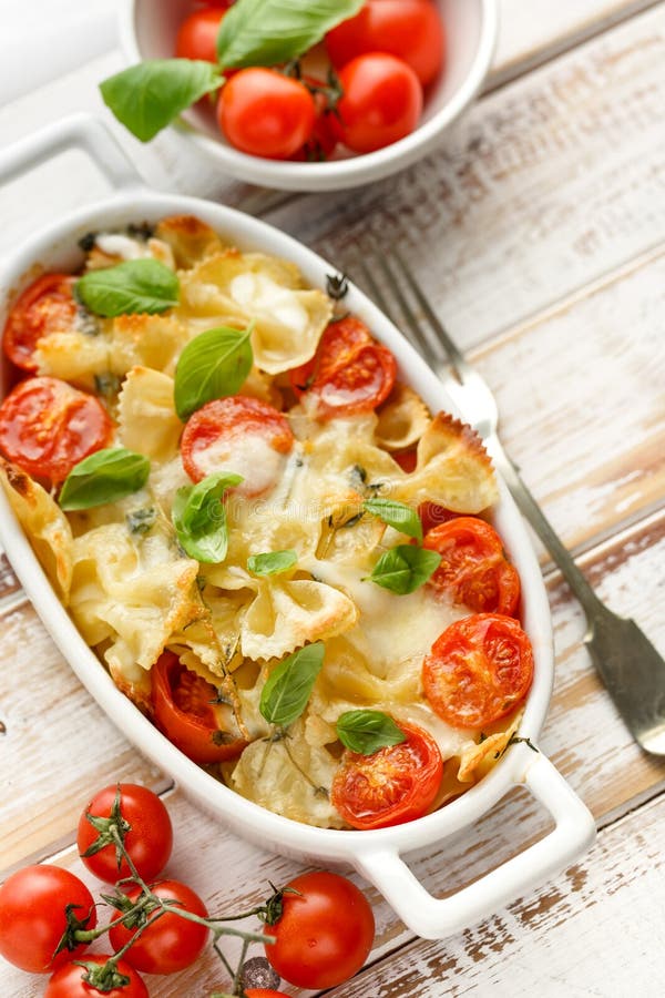 Casserole with farfalle pasta, cherry tomato, mozzarella cheese and herbs