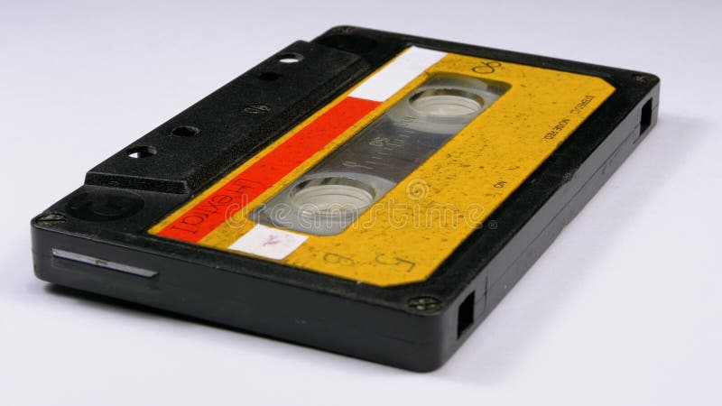A cassete áudio amarela do vintage gerencie no fundo branco
