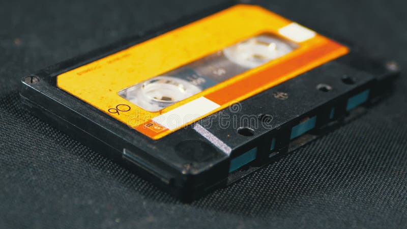 A cassete áudio amarela do vintage gerencie no fundo preto