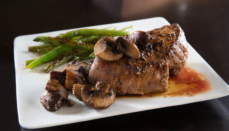 Cast iron pan seared tenderloin beef steak with portabella mushrooms