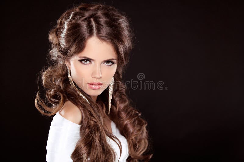 Castana. Donna di lusso con i capelli ricci lunghi di Brown. Modello di moda immagine stock libera da diritti Castana. Donna di lusso con i capelli ricci lunghi di Brown. Modello di moda immagine stock libera da diritti