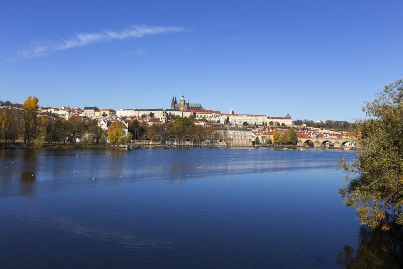 Castello di Praga di autunno variopinto e Charles Bridge gotici con Lesser Town nel giorno soleggiato, repubblica Ceca immagine stock libera da diritti Castello di Praga di autunno variopinto e Charles Bridge gotici con Lesser Town nel giorno soleggiato, repubblica Ceca immagine stock libera da diritti