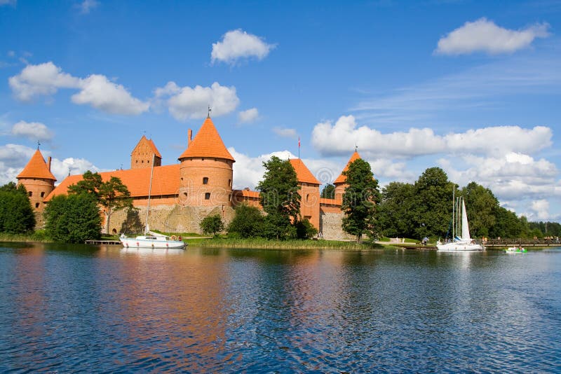 Panoramatický výhľad na staré červené multy veža hradu Trakai Litva modré jazero vody krásy zatiahnutej oblohe plávajú lode.