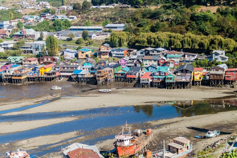 CASTRO, CHILE - 23 DE MARZO DE 2015: Barcos de pesca y casas del zanco de los palafitos durante marea baja en Castro, isla de Chi imagen de archivo CASTRO, CHILE - 23 DE MARZO DE 2015: Barcos de pesca y casas del zanco de los palafitos durante marea baja en Castro, isla de Chi imagen de archivo