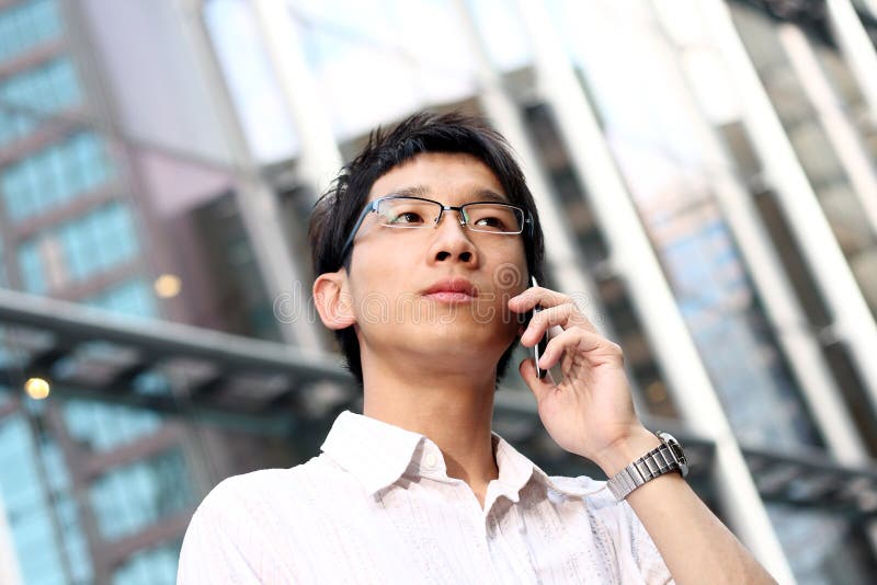 Casual asian businessman talking on his cell phone royalty free stock images