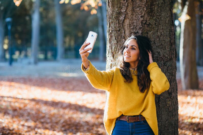 Young woman taking selfie photo with smart phone in autumn stock photos Young woman taking selfie photo with smart phone in autumn stock photos