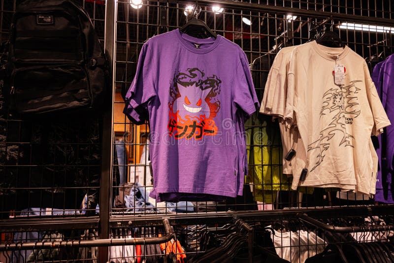 Casual de las camisetas gráficas colgadas en una moderna tienda de ropa imagenes de archivo