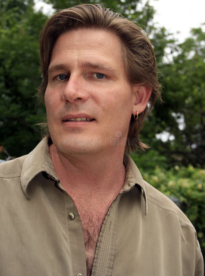 Portrait of a man in early forties, casually dressed, longish hair, earring. Portrait of a man in early forties, casually dressed, longish hair, earring.