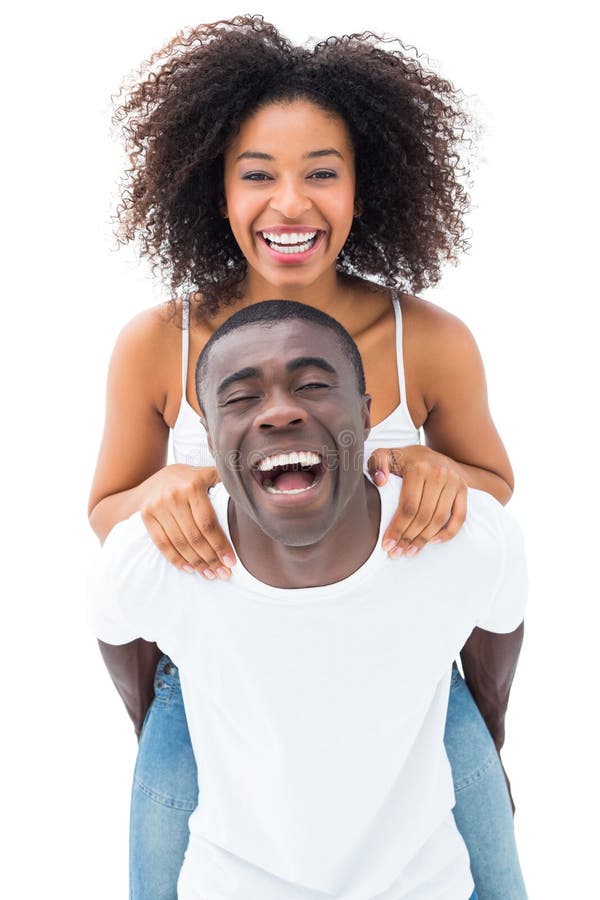 Casual men giving his smiling girlfriend a piggy back on white background.