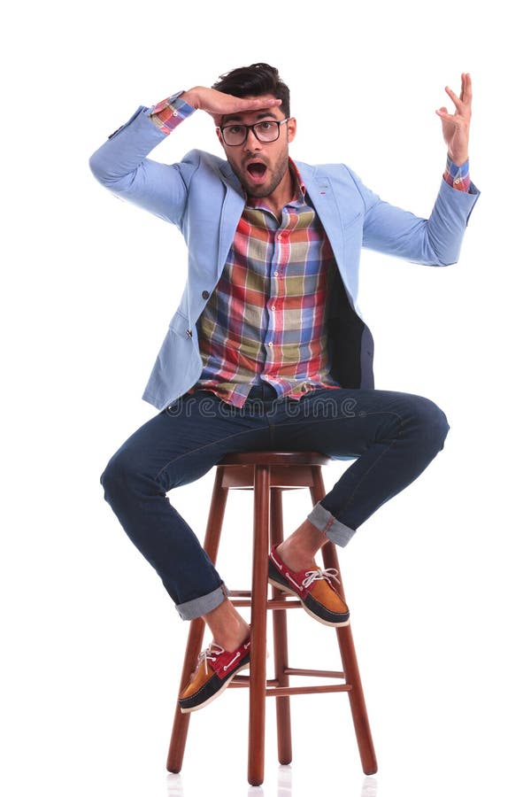 Casual man sitting while making a funny face royalty free stock photography Casual man sitting while making a funny face royalty free stock photography