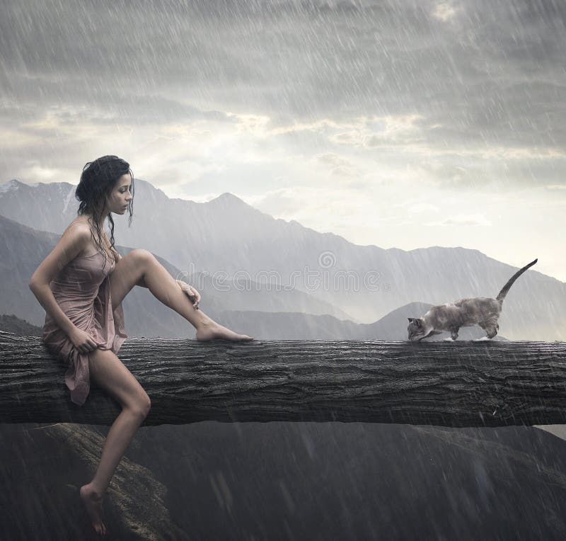 Giovane, donna e gatto su un tronco.