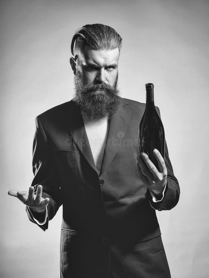 Catador del vino Hombre barbudo con la botella de vino imagenes de archivo Catador del vino Hombre barbudo con la botella de vino imagenes de archivo