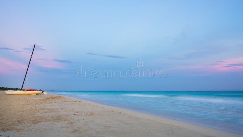 Catamarán en la puesta del sol en la playa fotografía de archivo Catamarán en la puesta del sol en la playa fotografía de archivo