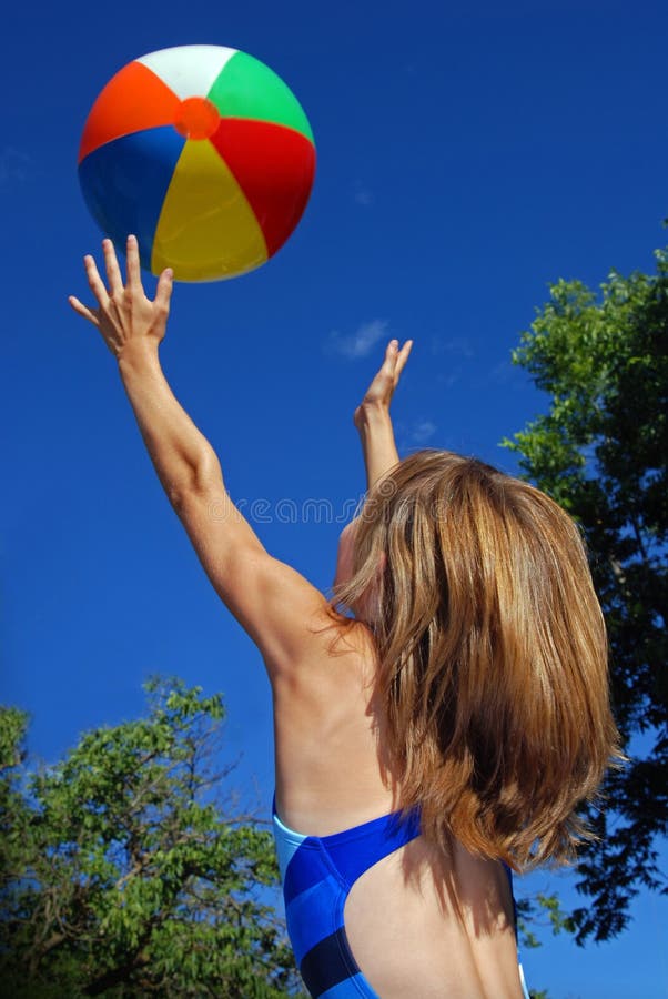 Mladé dievča s beach ball a modré nebo.