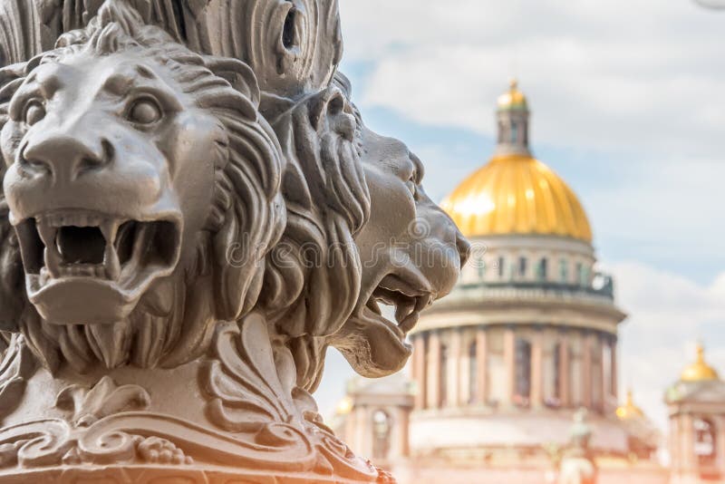 Catedral do ` s de Isaac de Saint fora de foco, no primeiro plano a escultura dos leões em uma coluna St Petersburg, Rússia