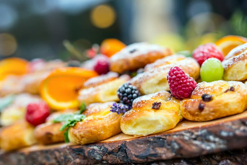 Catering buffet food outdoor. Cakes colorful fresh fruits berries oranges grapes and herb decorations