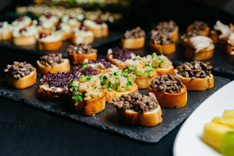Catering, food and drink concept - close up of different bruschettas with diced vegetables stock photo Catering, food and drink concept - close up of different bruschettas with diced vegetables stock photo