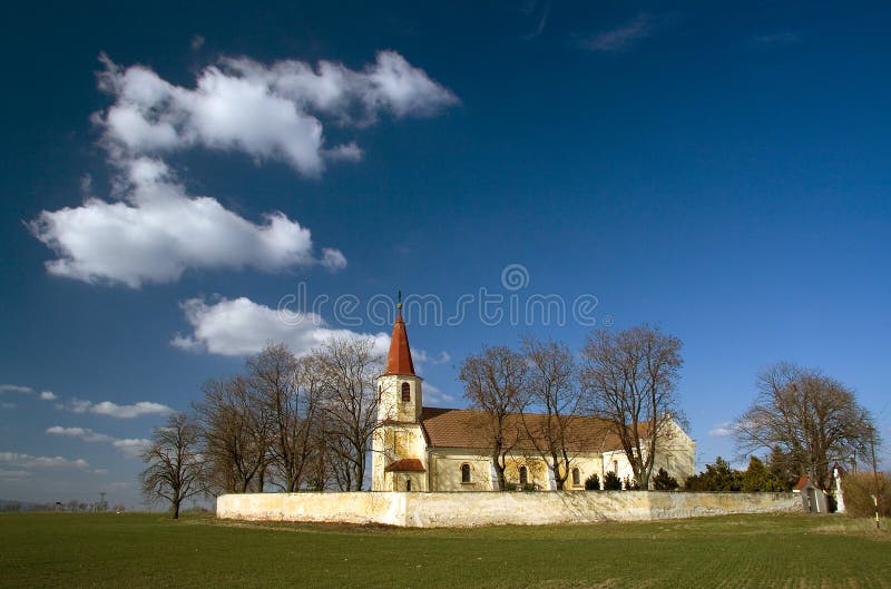 Katolický kostel v přírodě s mraky