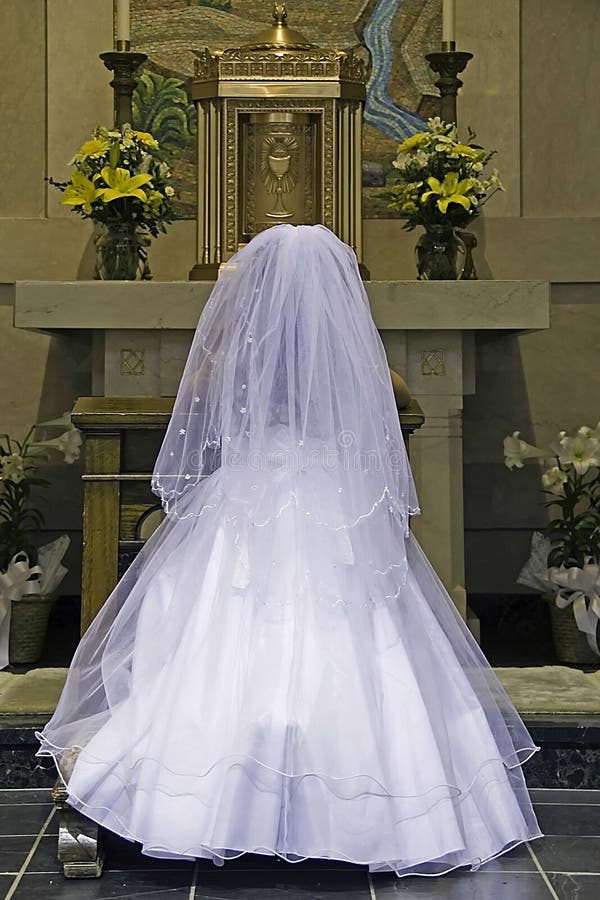 A Young Girl Prays in a Cathedral Prior to Her Holy Communion Ceremony. A Young Girl Prays in a Cathedral Prior to Her Holy Communion Ceremony.