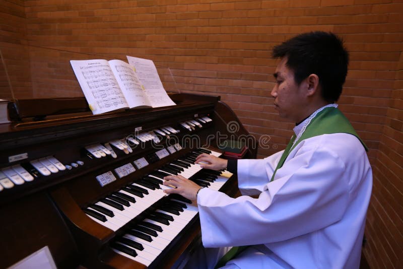 A Catholic priest playing the organ in the church. royalty free stock photos A Catholic priest playing the organ in the church. royalty free stock photos