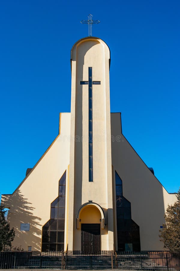 Catholic White Tower Church with Cross on a Deep Blue Sky Stock Photo