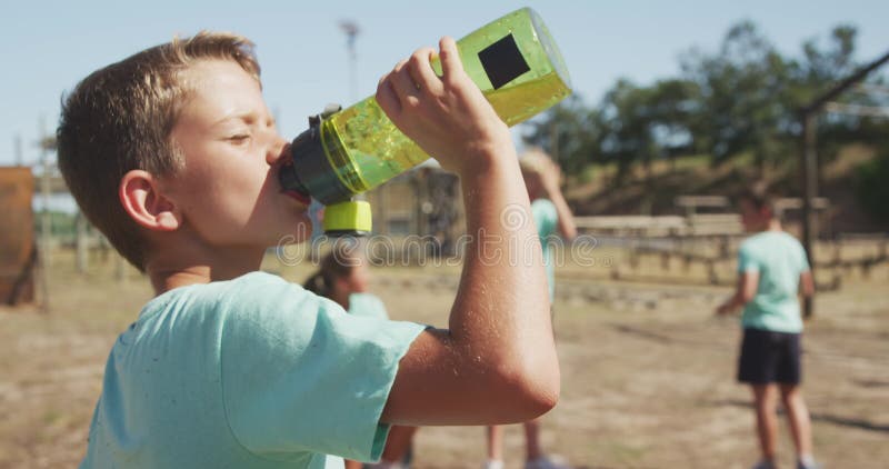 Caucasian boy drinking water at boot camp stock video footage