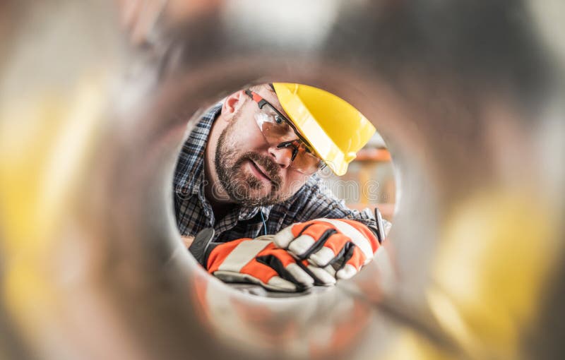 Worker Looking Inside Metal HVAC Pipe