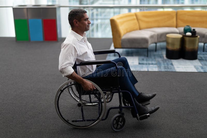 Caucasian disabled businessman sitting on wheelchair in office royalty free stock photo Caucasian disabled businessman sitting on wheelchair in office royalty free stock photo