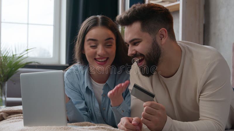 Caucasian family happy couple woman and man buy internet goods online shopping on bed wife and husband use bank credit