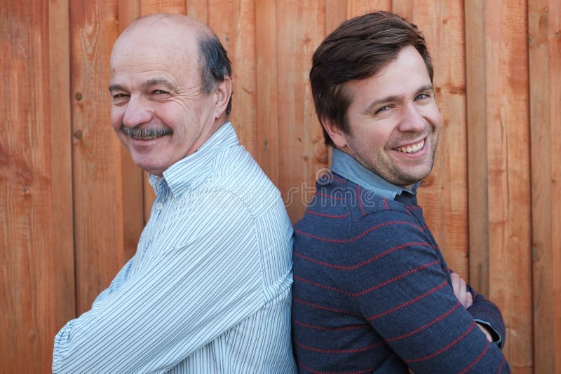 Caucasian father and adult son smiling and looking at camera royalty free stock image Caucasian father and adult son smiling and looking at camera royalty free stock image