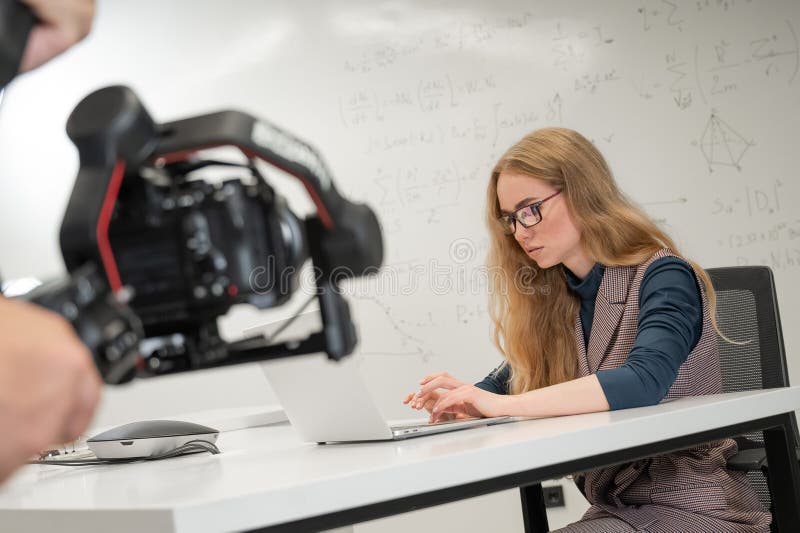 Caucasian female scientist typing on laptop. White board with formulas. Photo shoot. stock images